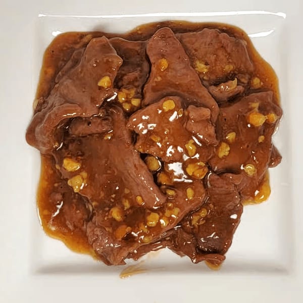 Double Happy's Chinese beef dish with a rich brown sauce and visible garlic pieces.